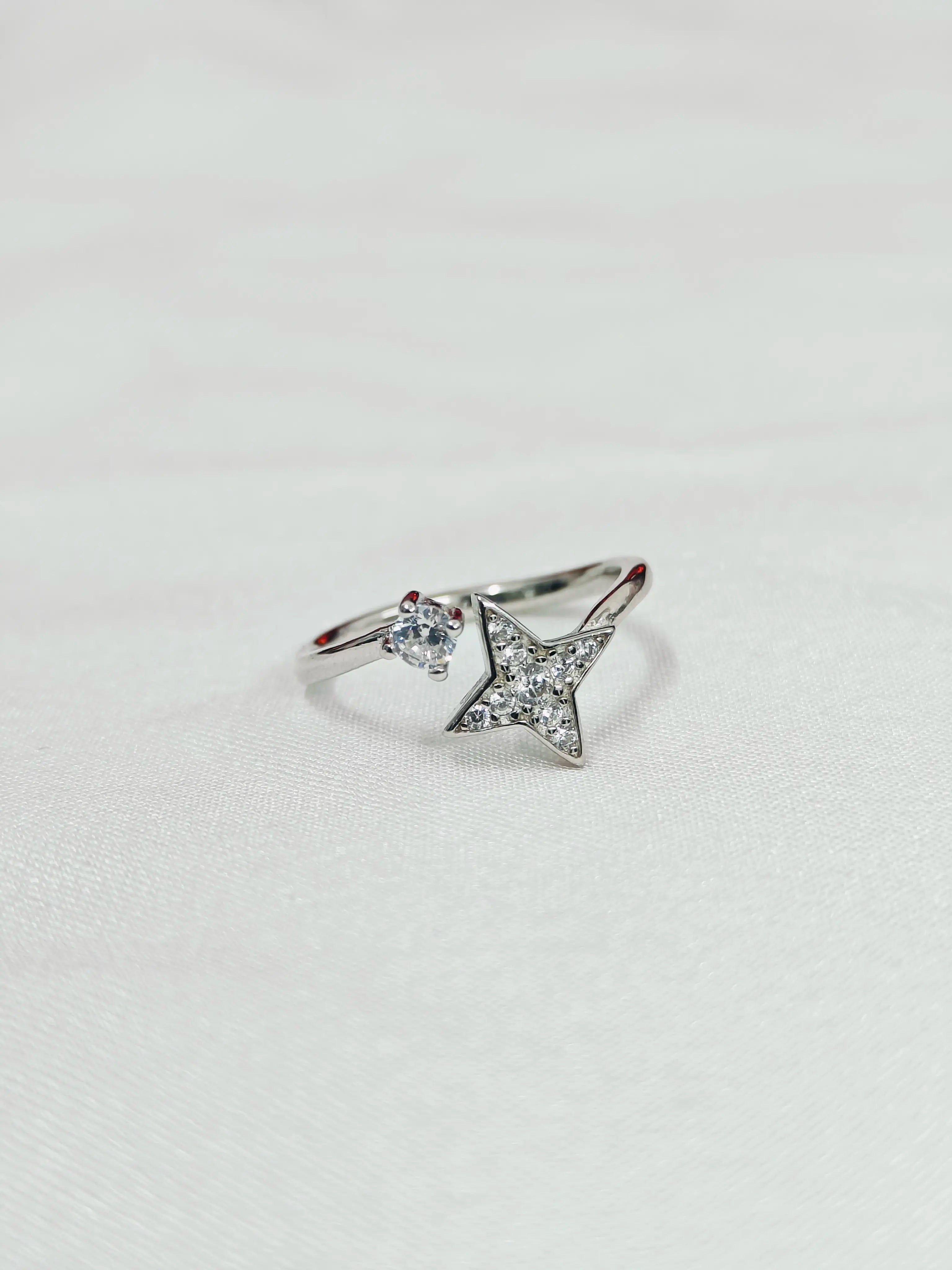 Silver ring with star design on a light gray background